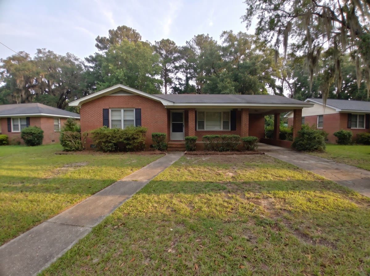 The same house with the yard cut down, shrubs cut back and the walkway clear