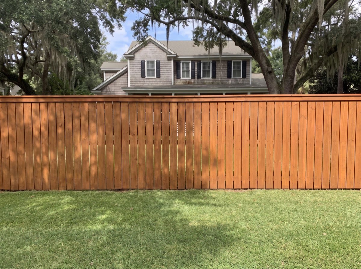 The same fence line rebuilt as an eight foot stained cedar privacy fence